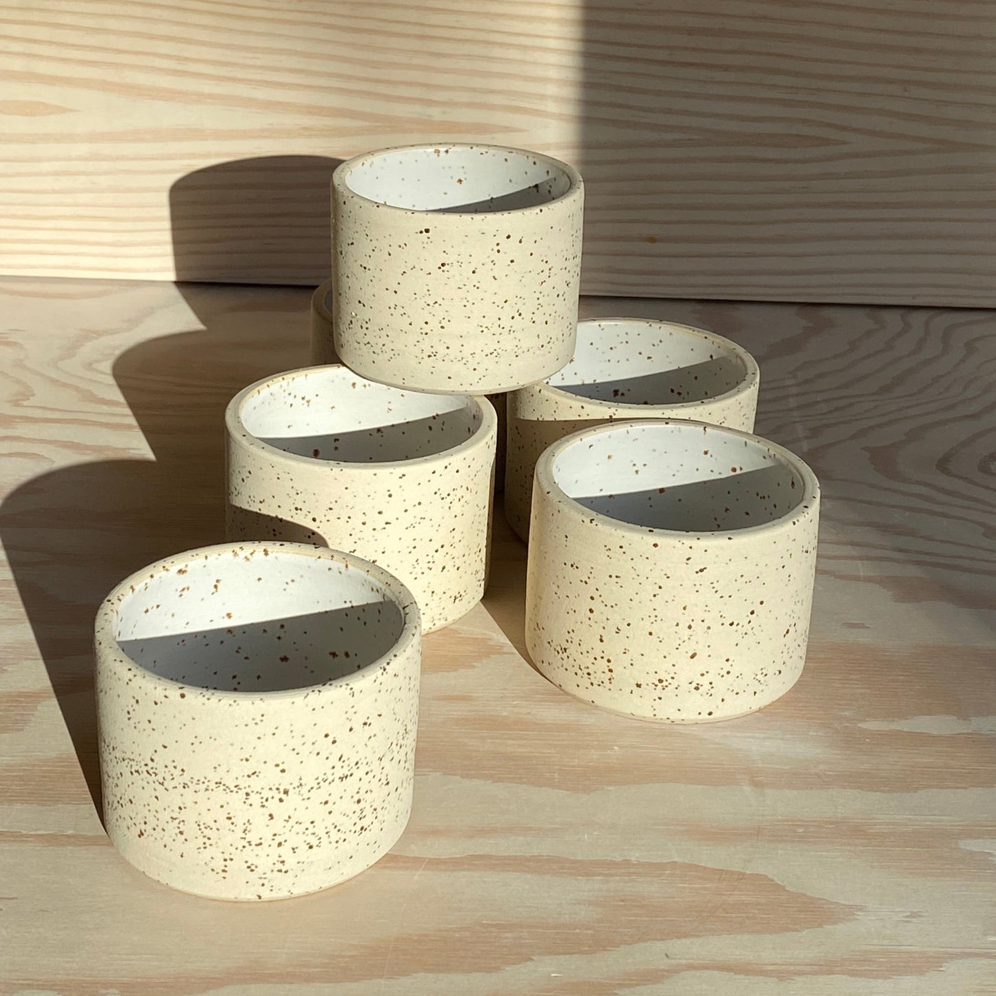 handgedrehter Becher aus Ton mit Spots in weiss matt