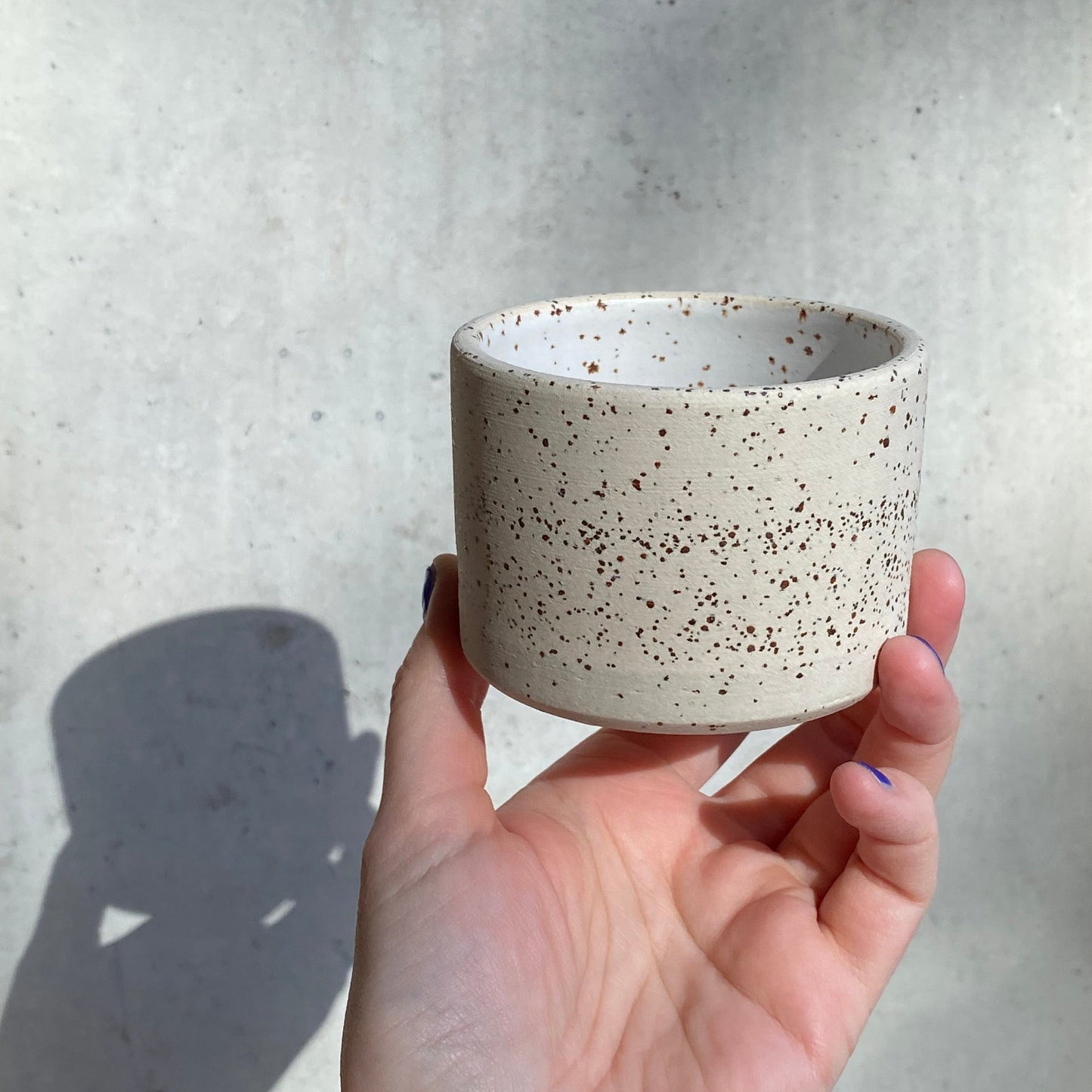 handgedrehter Becher aus Ton mit Spots in weiss matt