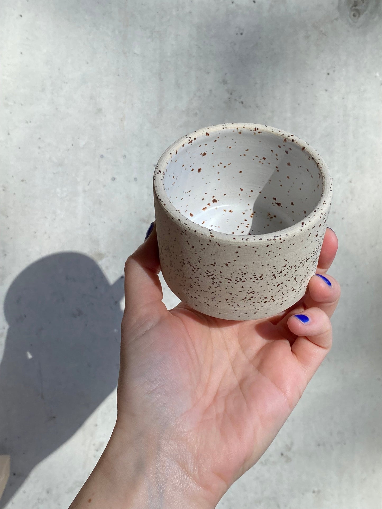 handgedrehter Becher aus Ton mit Spots in weiss matt