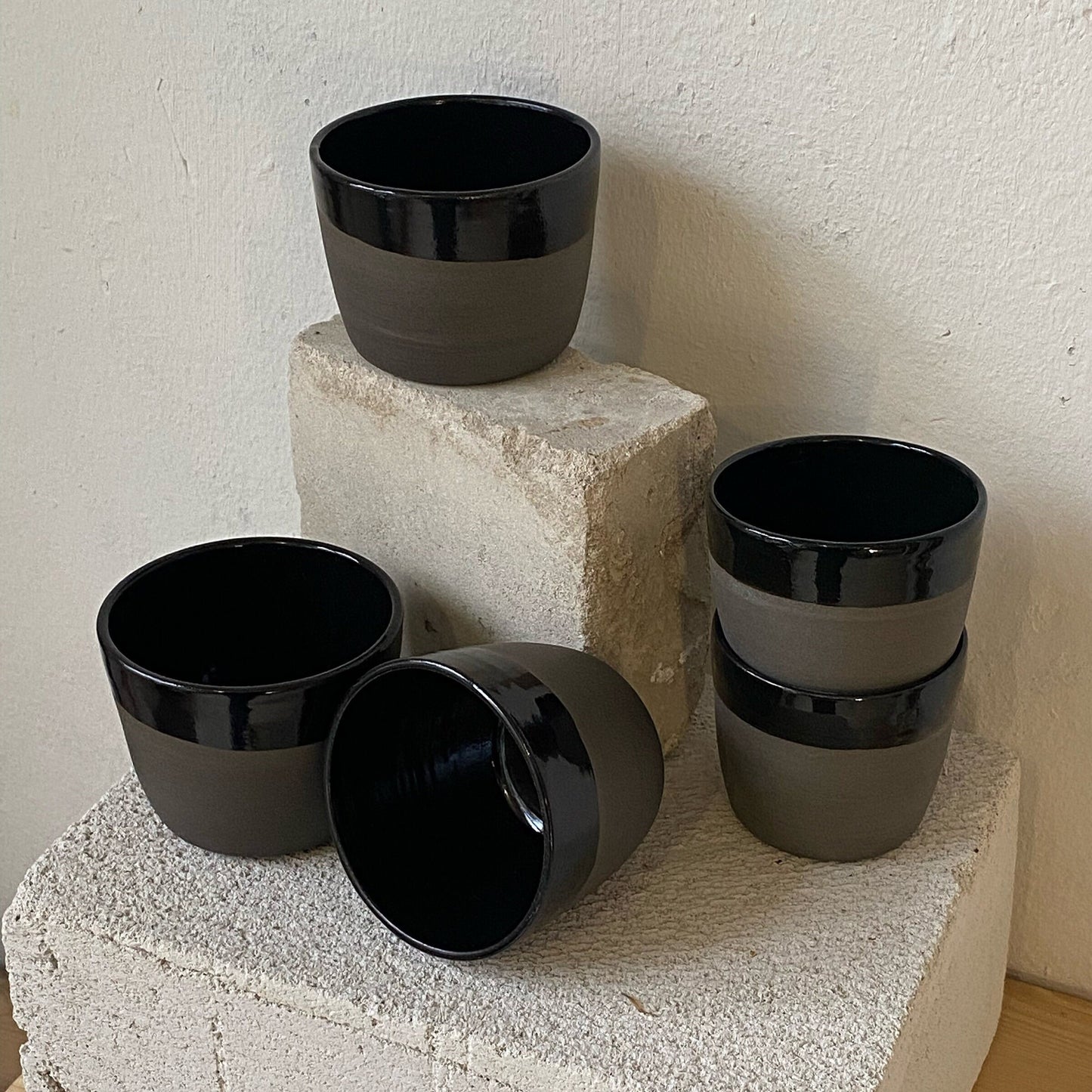 Keramik Becher aus grauem Ton, schwarz glänzend glasiert