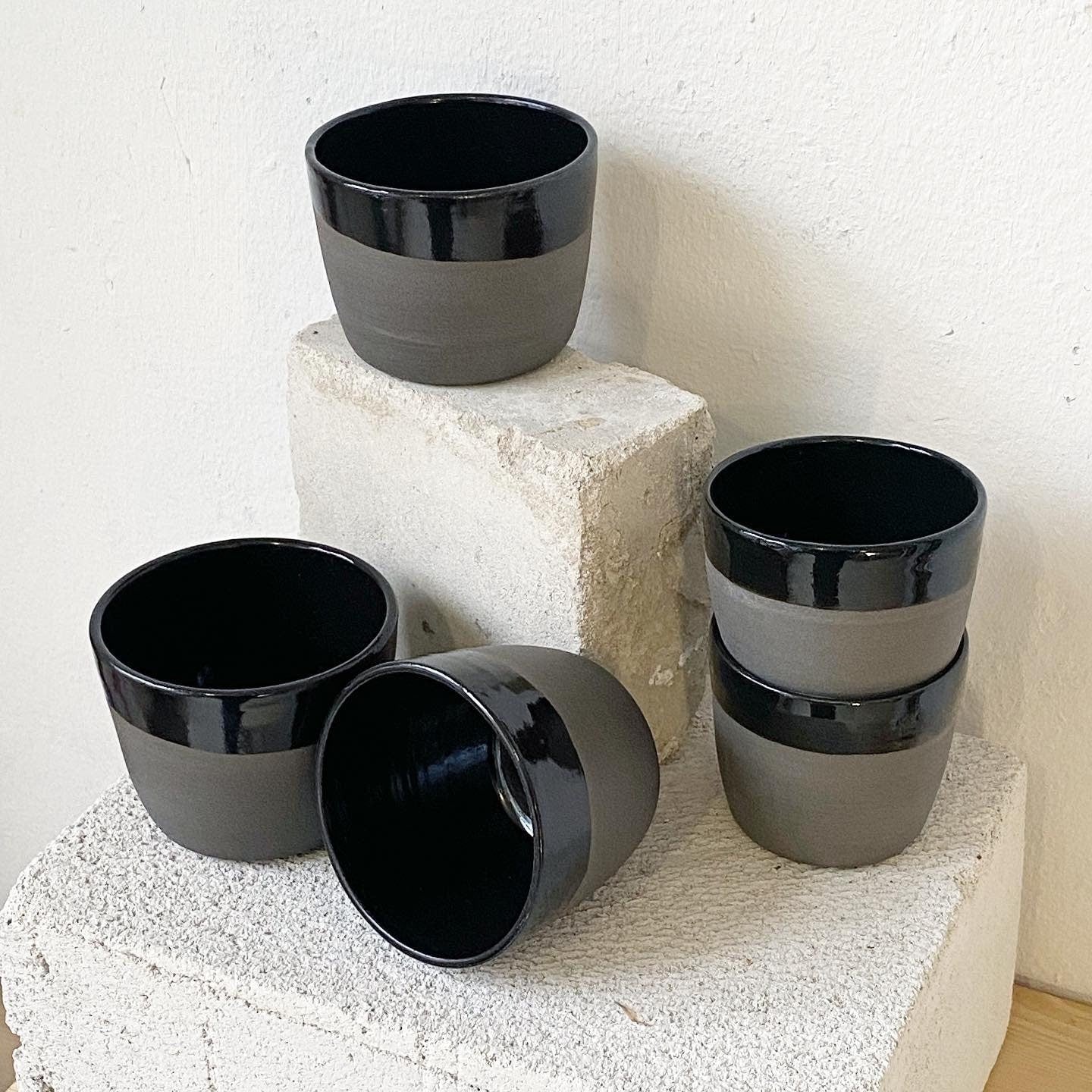 Keramik Becher aus grauem Ton, schwarz glänzend glasiert